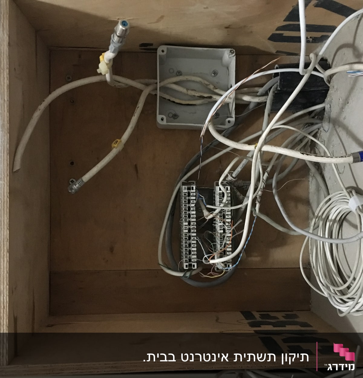 חוטי תקשורת ולוח חיבורים בתוך ארון עץ